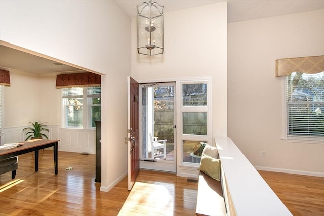 doorway with a high ceiling and light hardwood / wood-style flooring