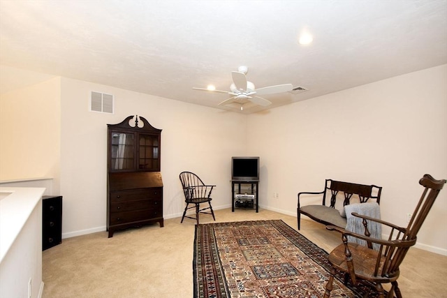 living area featuring ceiling fan and light carpet