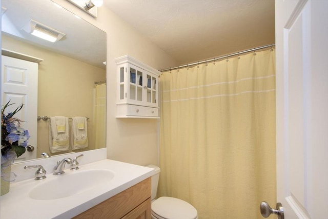 bathroom with curtained shower, vanity, and toilet