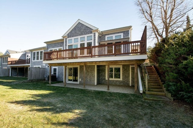 rear view of property featuring a lawn and a wooden deck