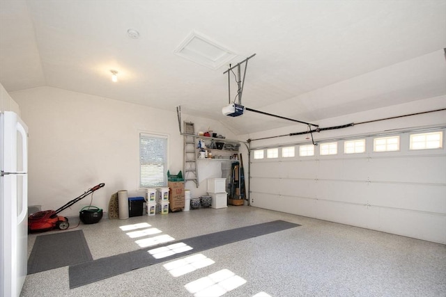 garage with a garage door opener and white refrigerator