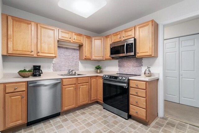 kitchen featuring backsplash, sink, stainless steel appliances, and light brown cabinets