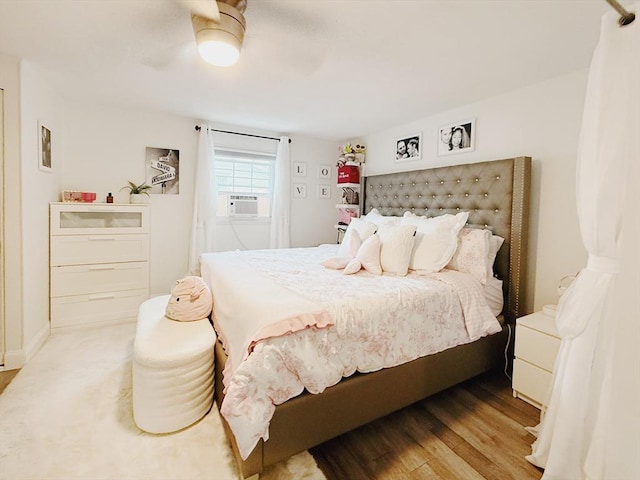 bedroom featuring cooling unit, a ceiling fan, and wood finished floors