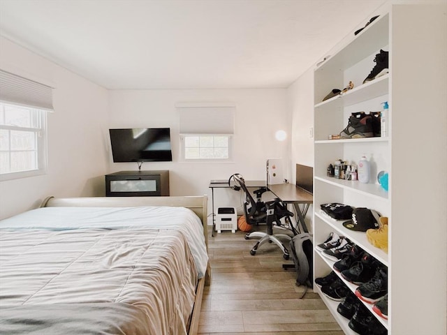 bedroom with wood finished floors and multiple windows