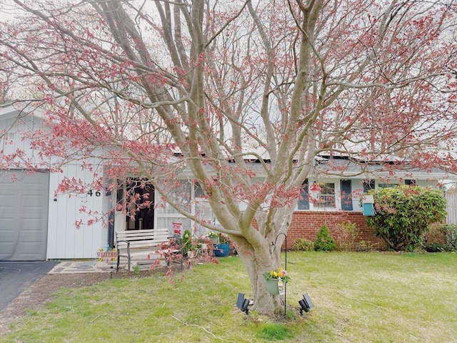 view of front of house with a front lawn, aphalt driveway, and brick siding