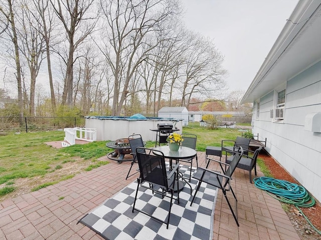 view of patio featuring a fenced in pool, cooling unit, outdoor dining area, and a fenced backyard