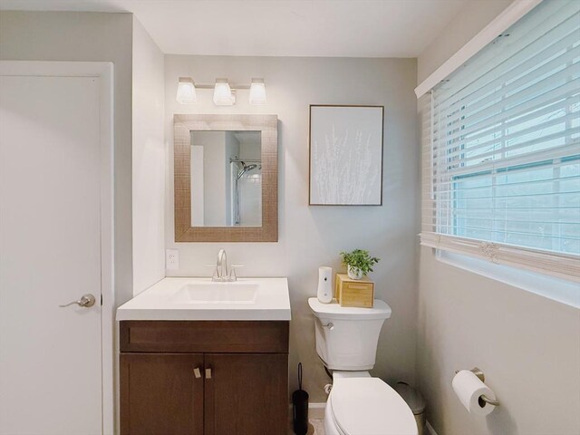 full bath with walk in shower, vanity, and toilet