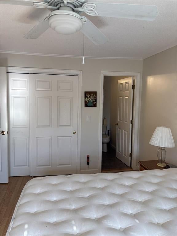 12 Candlewood Ln Unit 2-2, Dennis, MA 02639 - bedroom featuring a closet, a ceiling fan, ornamental molding, wood finished floors, and ensuite bathroom