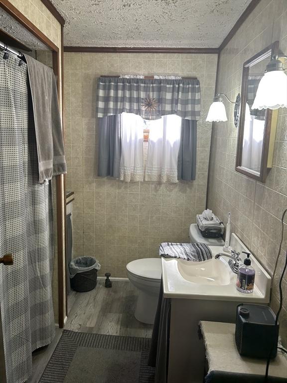 121 Kellogg St, Fall River, MA 02721 - full bath with tile walls, a textured ceiling, vanity, crown molding, and wood finished floors