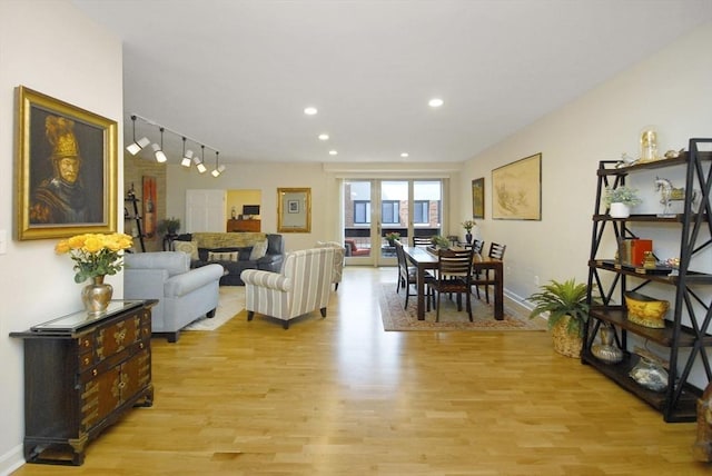 living area featuring baseboards, recessed lighting, and light wood-style flooring