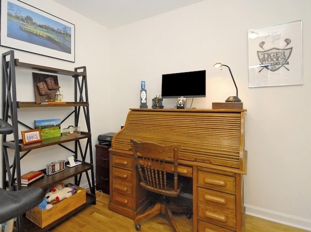 home office with baseboards and light wood-style flooring