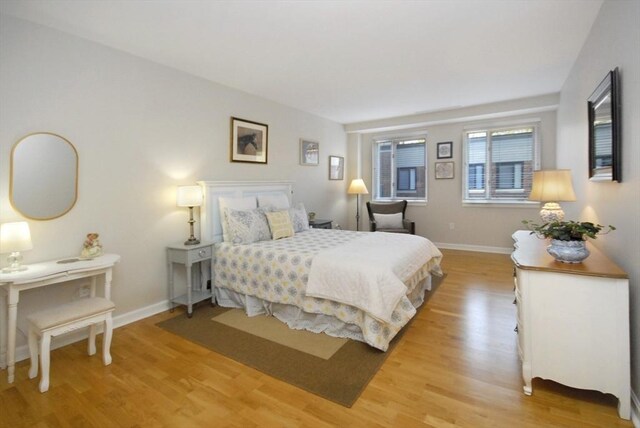 bedroom featuring baseboards and light wood finished floors