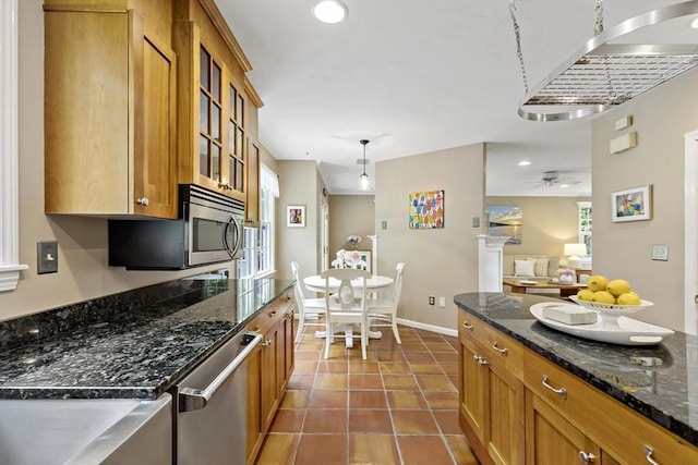 7 Lauras Ln, Marshfield, MA 02050 - kitchen with appliances with stainless steel finishes, brown cabinetry, glass insert cabinets, dark stone counters, and recessed lighting