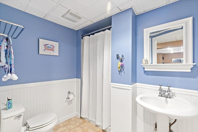 7 Lauras Ln, Marshfield, MA 02050 - bathroom featuring toilet, wainscoting, curtained shower, tile patterned flooring, and a sink