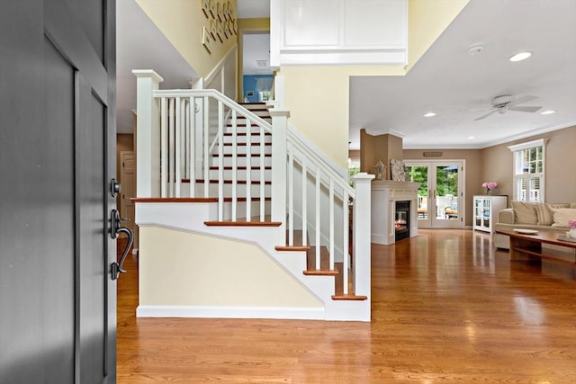 7 Lauras Ln, Marshfield, MA 02050 - foyer entrance with wood finished floors, a glass covered fireplace, a ceiling fan, stairway, and ornamental molding