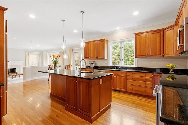 kitchen featuring a sink, light wood-style floors, and brown cabinetry