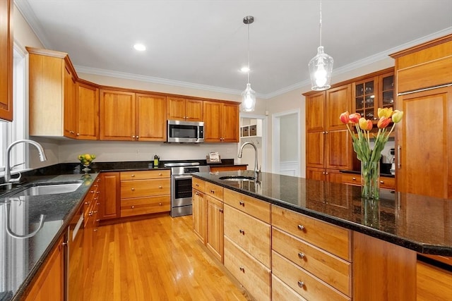 kitchen with brown cabinetry, a sink, light wood finished floors, and stainless steel appliances