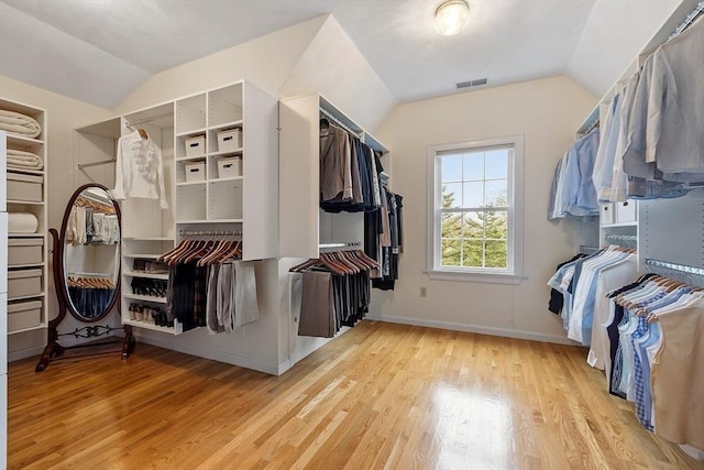 spacious closet featuring visible vents, wood finished floors, and lofted ceiling