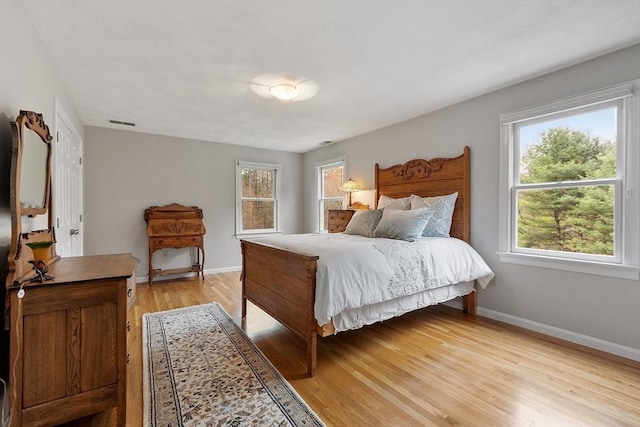 bedroom featuring light wood-style floors, baseboards, and visible vents