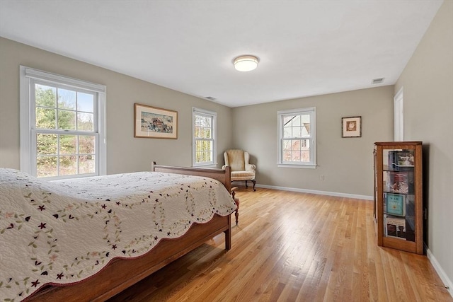 bedroom featuring light wood-type flooring, baseboards, and visible vents