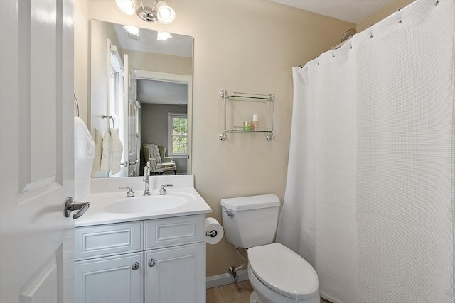 bathroom with toilet, baseboards, and vanity