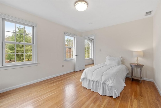 bedroom with baseboards, multiple windows, and visible vents