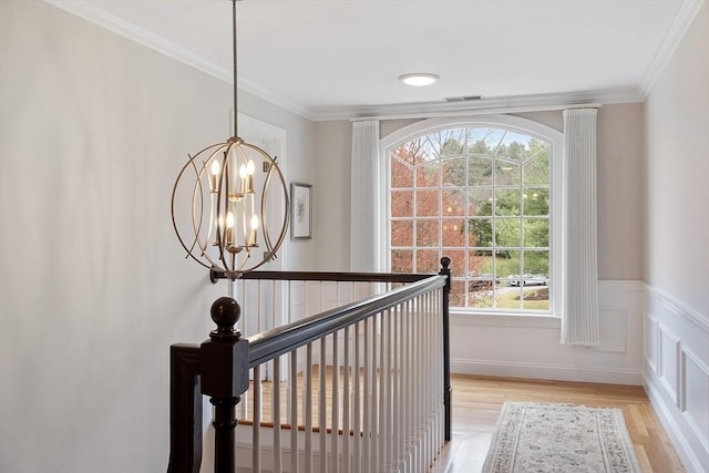 interior details with an inviting chandelier, crown molding, wood finished floors, and visible vents