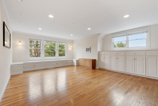 interior space featuring crown molding, light wood-style flooring, baseboards, and a wealth of natural light