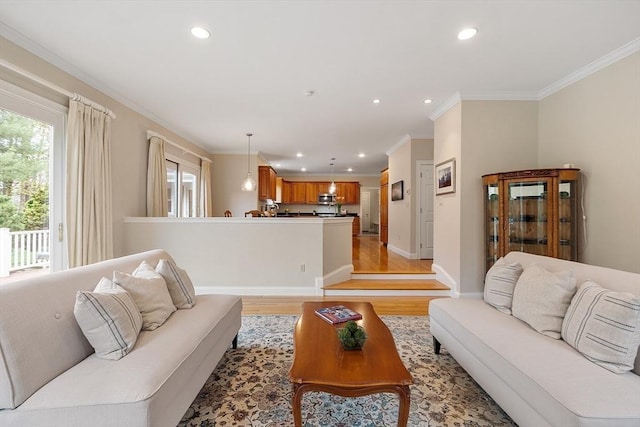 living room with crown molding, recessed lighting, baseboards, and light wood-style flooring