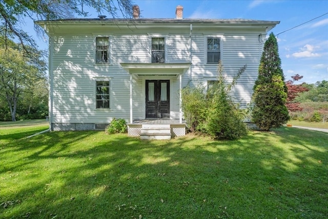 back of house featuring a lawn