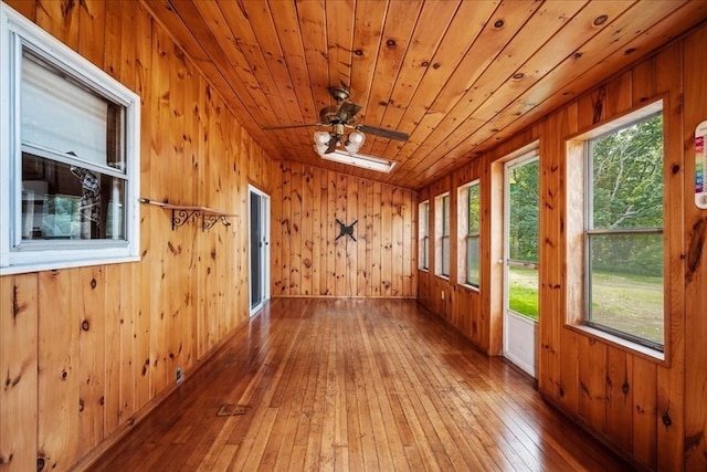 unfurnished sunroom with wooden ceiling, vaulted ceiling with skylight, and ceiling fan