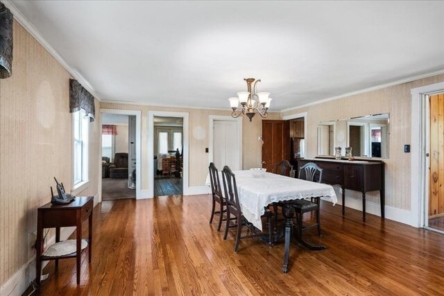 dining space with ornamental molding, light hardwood / wood-style flooring, and a chandelier