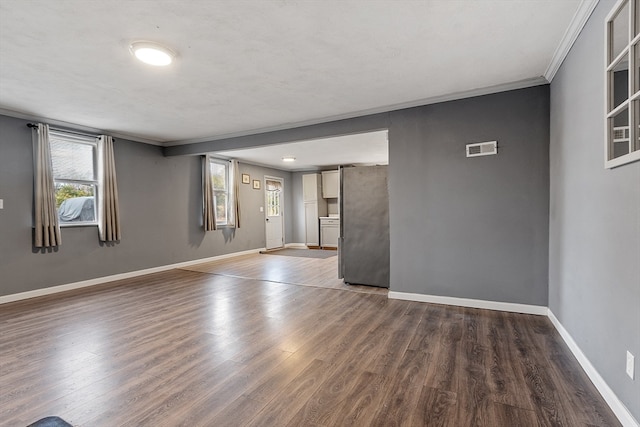 spare room featuring ornamental molding and dark wood-type flooring