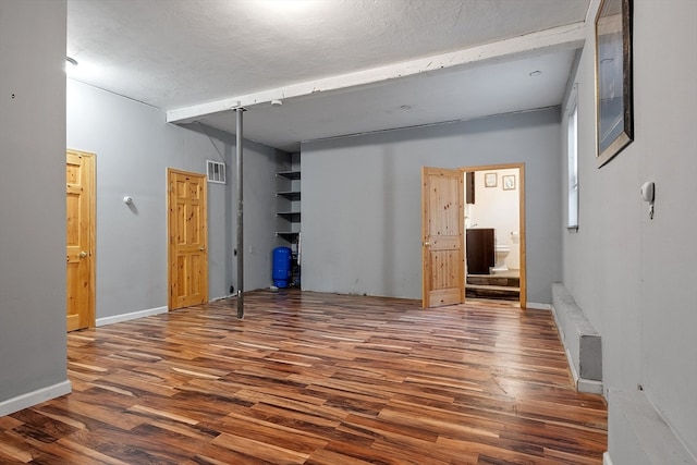 unfurnished bedroom with dark hardwood / wood-style flooring and a textured ceiling