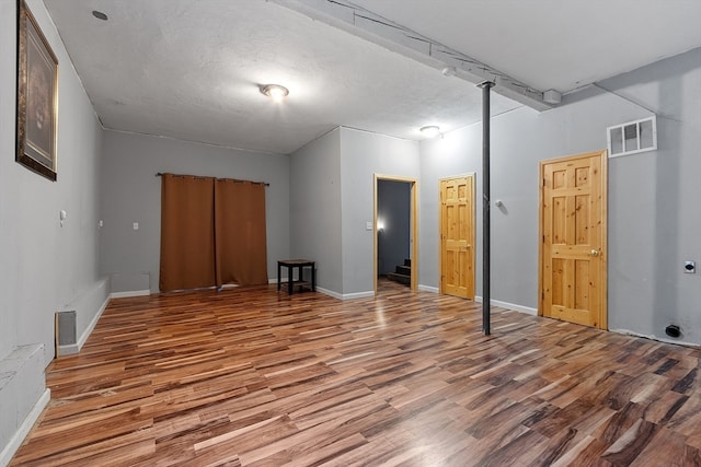 unfurnished bedroom with wood-type flooring and a textured ceiling