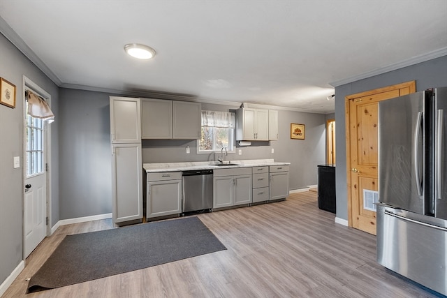 kitchen with gray cabinets, stainless steel appliances, and light hardwood / wood-style flooring