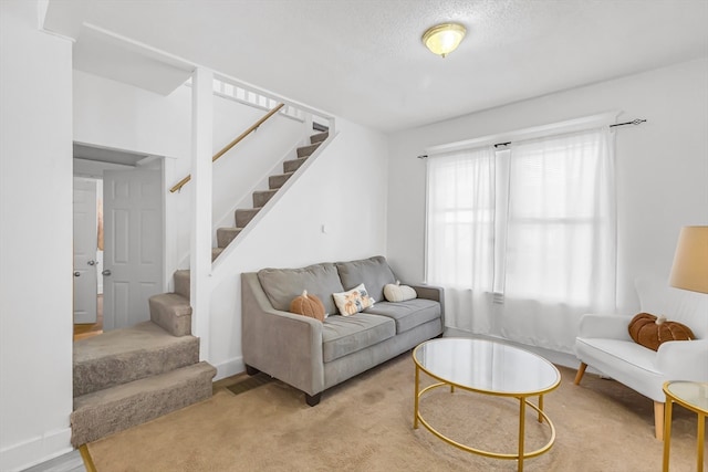 carpeted living room featuring a textured ceiling