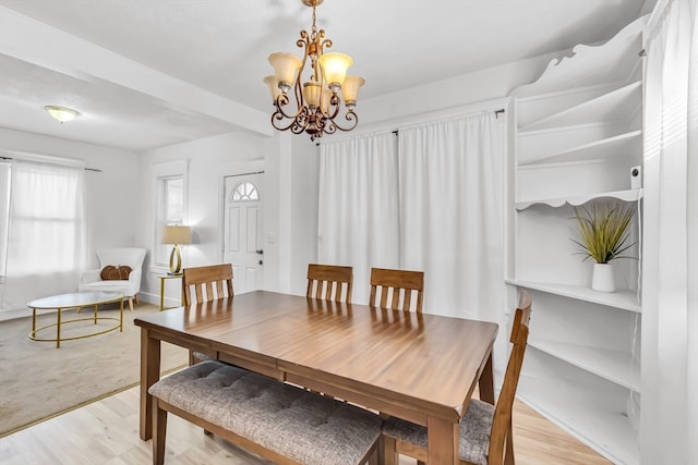 dining space featuring light hardwood / wood-style flooring and an inviting chandelier