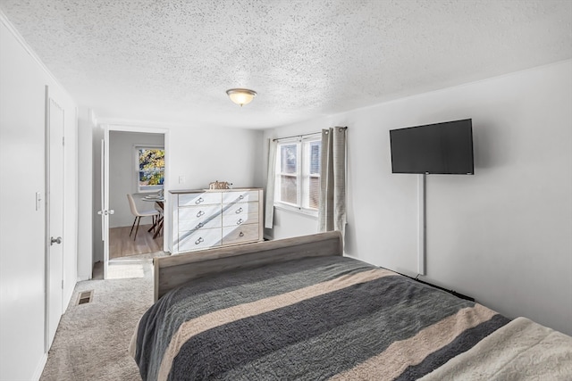 bedroom with carpet and a textured ceiling