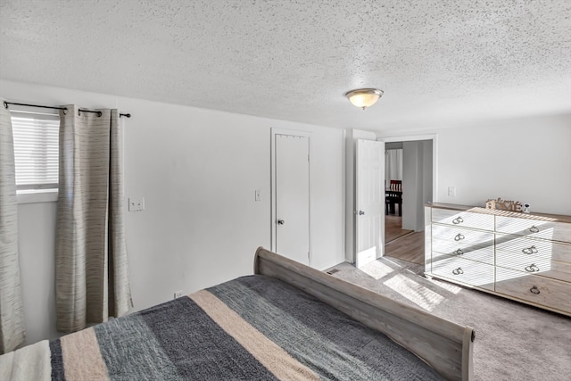 carpeted bedroom featuring a textured ceiling