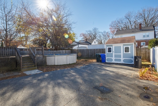 view of yard featuring a storage shed and a pool side deck