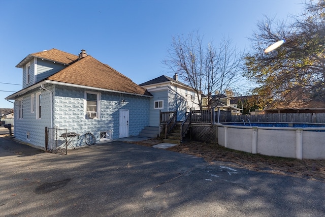 back of property with a pool side deck