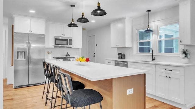90 Fox Farms Rd, Northampton, MA 01062 - kitchen featuring appliances with stainless steel finishes, a sink, a kitchen island, light wood-style floors, and tasteful backsplash