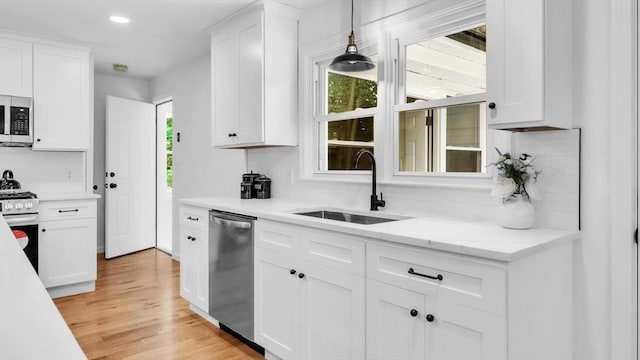 90 Fox Farms Rd, Northampton, MA 01062 - kitchen with appliances with stainless steel finishes, a sink, white cabinetry, backsplash, and light wood finished floors