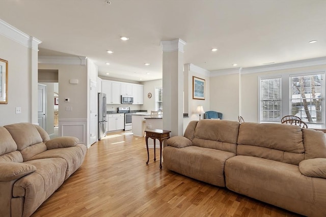 living area with light wood finished floors, recessed lighting, crown molding, and ornate columns