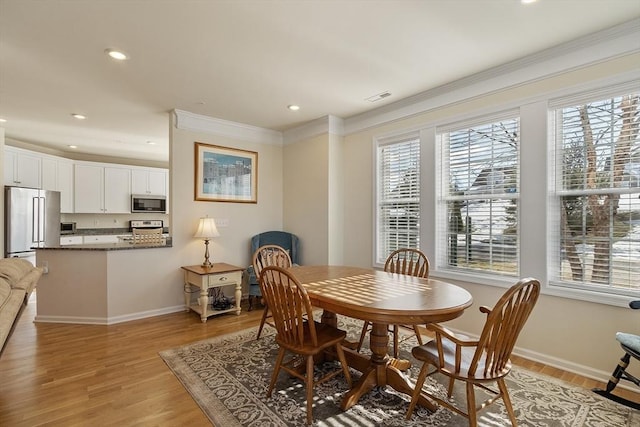 dining area featuring baseboards, ornamental molding, visible vents, and light wood-style floors