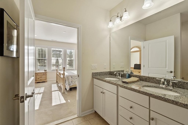 ensuite bathroom featuring double vanity, tile patterned flooring, a sink, and ensuite bathroom