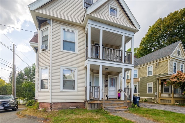 view of front of property featuring a balcony, cooling unit, and a porch