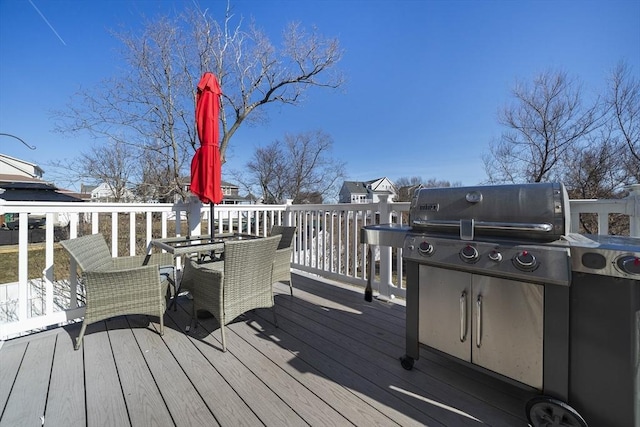 deck with outdoor dining space and area for grilling