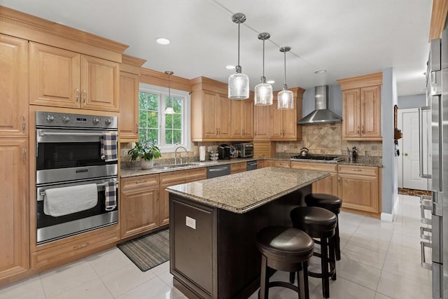 kitchen with wall chimney exhaust hood, appliances with stainless steel finishes, light stone countertops, decorative backsplash, and a center island